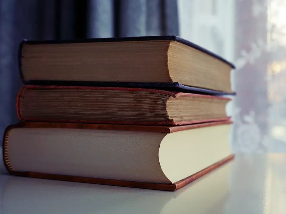 Sample image: A small stack of books by a sunlit window