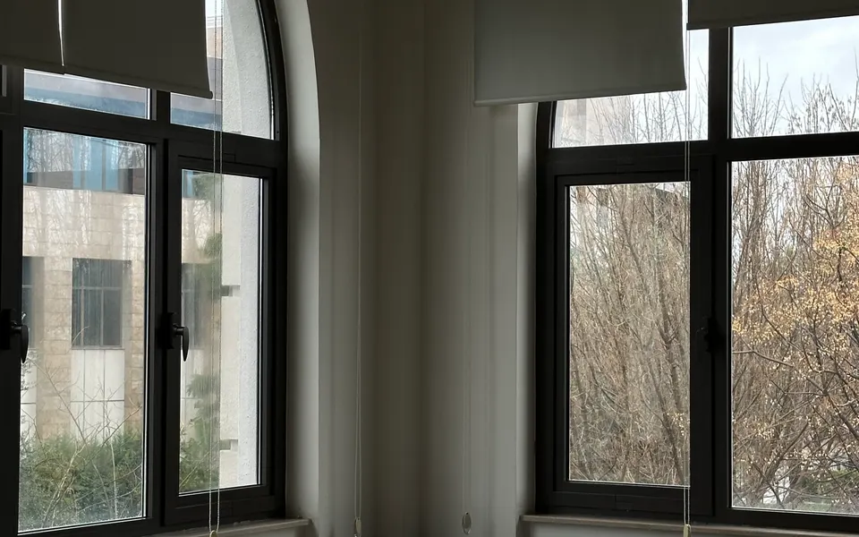 Sample image: An empty, sunlit classroom with desks and large windows