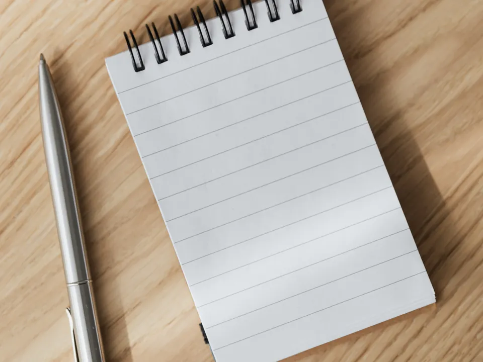Sample image: A blank notebook and pen on a wooden desk