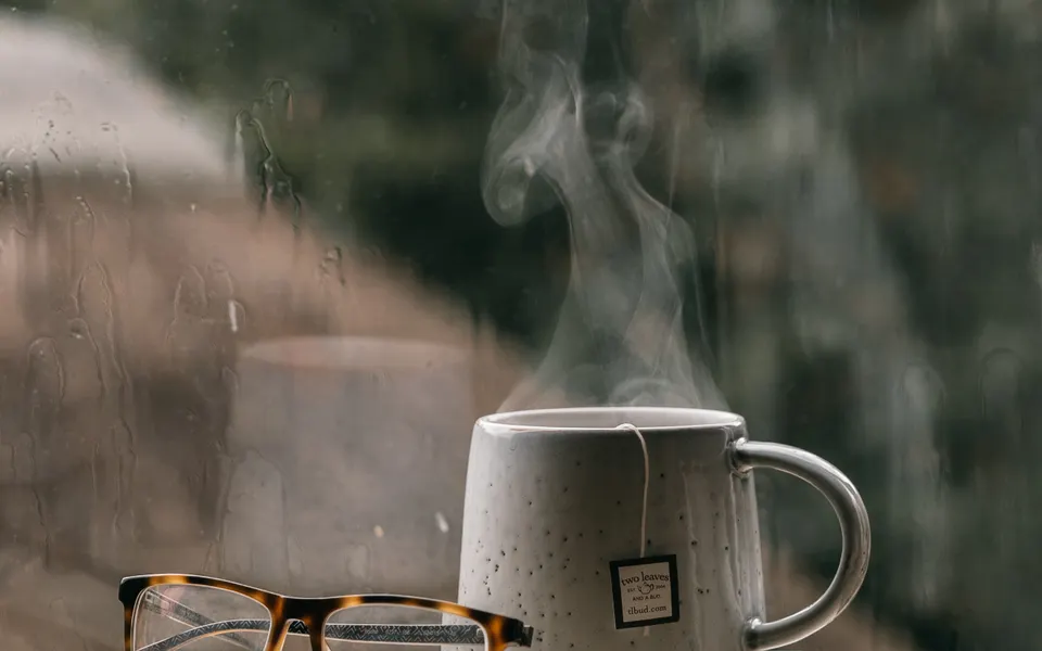 Sample image: A cup of tea on a stack of books beside a rainy window